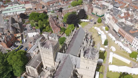 Rising-aerial-view-of-the-center-of-Exeter-featuring-the-cathedral-and-surrounding-grounds,-highlighting-the-urban-landscape