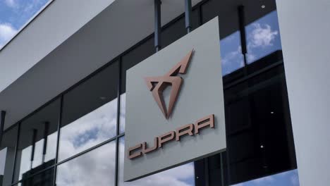 Supra-logo-sign-hanging-from-dealership-facade-with-modern-architecture,-Exeter,-Devon,-UK,-June-2024