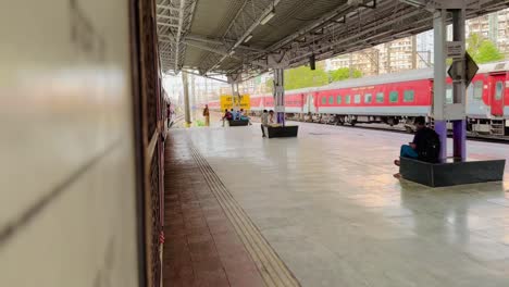 Indian-local-railway-train-leaves-the-station-as-passenger-train-runs-in-parallel