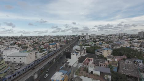 Toma-Aérea-De-Un-Tren-Que-Pasa-Por-La-Ciudad-De-Tráfico-Medio