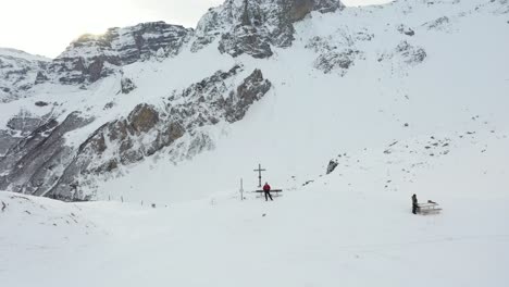 drone-flight-in-a-beautiful-snowy-landscape-with-a-cross-on-the-mountain-top