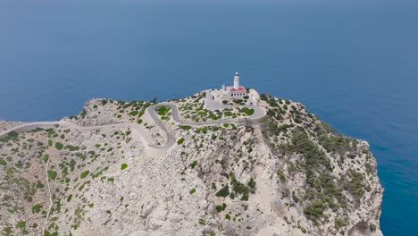 Aerial-circular-motion-around-Formentor-Lighthouse-on-cliff-edge,-Mallorca