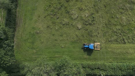 Drohnenansicht-Eines-Traktors,-Der-Mit-Einem-Grasmäher-Silage-Für-Tierfutter-In-Der-Landschaft-Von-Devonshire-Herstellt