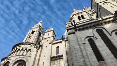 Bewegte-Kamera-Mit-Blick-Nach-Oben-Zur-Berühmten-Basilika-Sacré-Coeur-In-Der-Region-Montmartre-An-Einem-Tag-Mit-Blauem-Himmel---Paris,-Frankreich