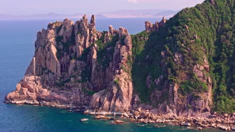 This-footage-captures-the-rugged-cliffs-and-lush-greenery-of-a-small-island-on-the-way-to-Da-Nang,-Vietnam