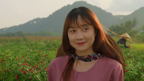 young-chinese-asiatic-farmer-wearing-bamboo-rice-hat-working-in-farm-plantation,-close-up-portrait-on-sunshine