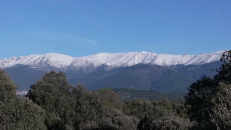 Filming-with-a-70mm-drone-in-the-Tiétar-valley-where-we-see-with-a-lateral-flight-the-fascinating-forest-that-the-valley-has-and-in-the-background-the-mountains-with-their-snow-capped-peaks