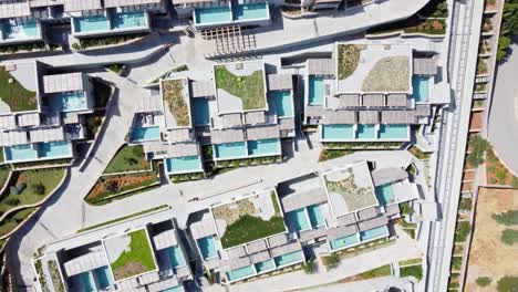 View-of-Cayo-Resort-in-Greece-Crete---drone-flies-bird's-eye-view-over-the-resort---houses-and-many-terrace-pools-can-be-seen