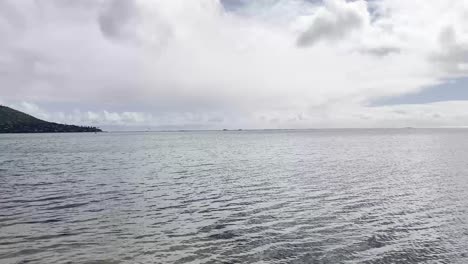 Eine-Ruhige-Strandszene-Auf-Oahu,-Hawaii,-Mit-Ruhigem-Wasser-Und-Einem-Fernblick-Auf-Palmen-Und-Die-Küste