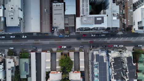 Aerial-top-down-of-traffic-on-main-street-in-modern-district-of-Melbourne-Town,-Australia