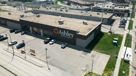 El-Dron-Se-Aleja-Del-Letrero-De-Ashley-Homestore-Para-Revelar-Toda-La-Tienda-Y-Sus-Alrededores