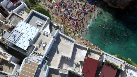 Downward-angle-drone-shot-of-Lama-Monachile-beach-on-a-sunny-day-in-Puglia,-Italy