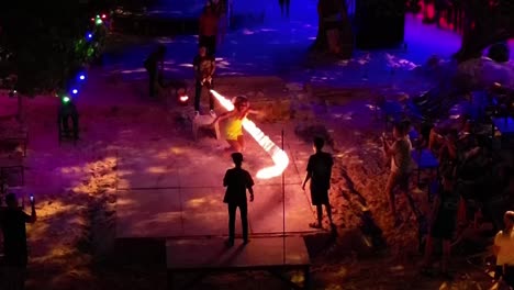 Tourist-Woman-Skipping-Fire-Rope-at-Thai-Beach-Party-Amidst-People-Crowd