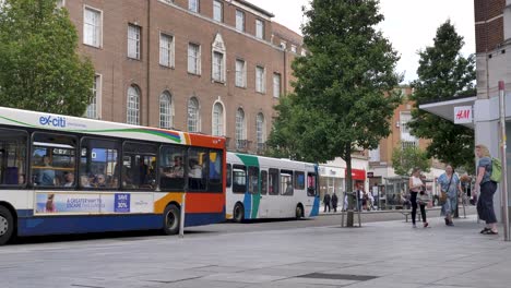 Buses-and-pedestrians-on-the-main-high-street,-Exeter-Devon-UK,-June-2024