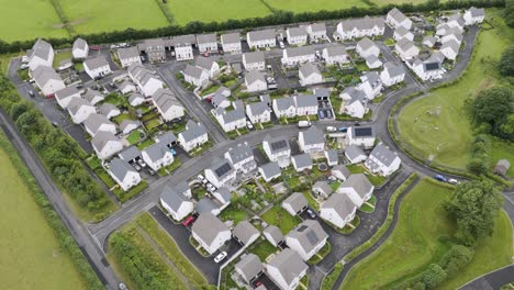 Aerial-view-of-new-build-homes-in-the-UK-countryside,-highlighting-the-modern-residential-architecture-amidst-green-surroundings