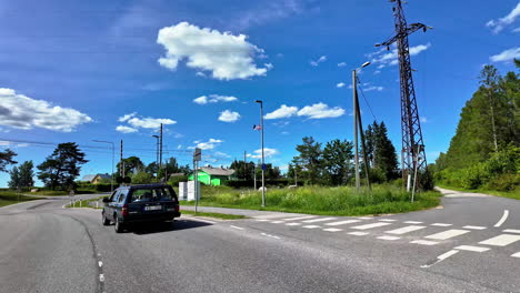 Behind-old-model-Volvo-car,-crossing-train-tracks-patch-on-main-road,-Riga-Latvia