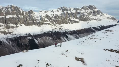 Drohnenflug-In-Einer-Wunderschönen-Schneelandschaft-Mit-Einem-Kreuz-Auf-Dem-Berggipfel