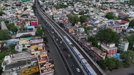 Luftaufnahme-Einer-Drohne-über-Der-Stadt-Chennai-Mit-Vorbeifahrender-U-Bahn