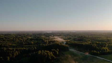 Aerial-View-of-dusty-countryside-gravel-road-in-sunset