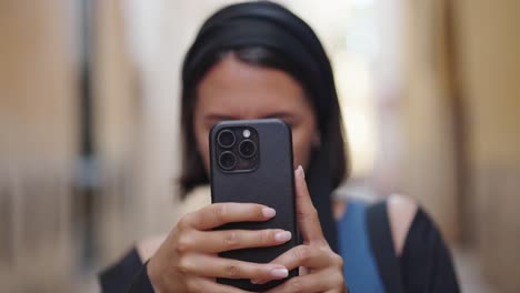 Caucasian-female-tourist-in-Mallorca-hold-smartphone-and-take-photos