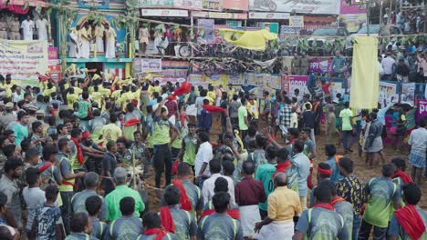 Wide-shot-of-people-cheering-as-they-arrive-to-take-part-in-the-annual-bull-taming-sport-of-Jallikattu,-celebrated-during-the-harvest-festival-of-Pongal-in-Tamil-Nadu