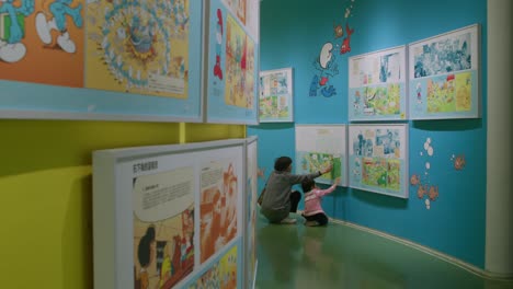 Padre-E-Hija-Viendo-Arte-De-Los-Pitufos-En-El-Museo-De-Arte-Jc-Cartoon