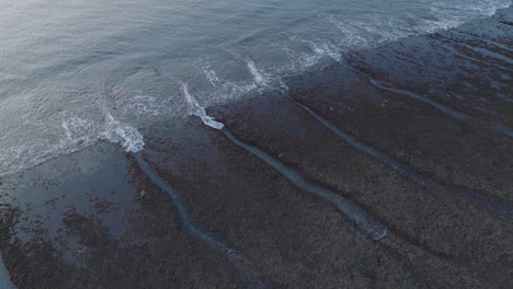 Toma-Panorámica-Con-Drones-Del-Arrecife-De-Marea-Baja-De-La-Playa-De-Bingin-Al-Atardecer-En-Uluwatu,-Bali,-Indonesia