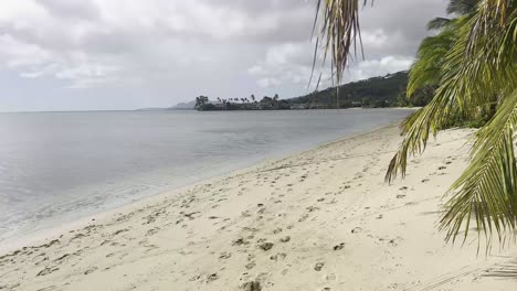 Ein-Ruhiger-Strand-Auf-Oahu,-Hawaii,-Mit-Fußspuren-Im-Sand,-Die-Entlang-Der-Küste-Führen