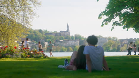 Focus-shift-between-people-at-the-park-and-the-cathedral-of-Annecy,-France