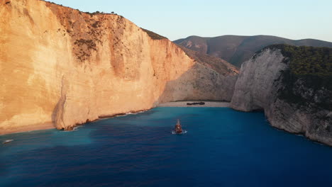 Cinematic-wide-drone-shot-of-Navagio-Beach-with-cruise-ship-in-the-harbor