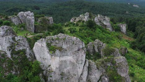 Drone-shot-of-a-climber-rock-climbing-on-the-beautiful-rock-of-Zborow-Hills-surrounded-by-natural-forest