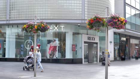 Exterior-of-NEXT-store-on-main-high-street-with-pedestrians-and-window-displays,-Exeter-Devon-UK,-June-2024