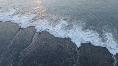 Panning-Drone-shot-of-Bingin-Beach-low-tide-reef-at-sunset-in-Uluwatu-Bali-Indonesia