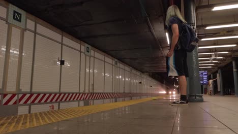 Man-with-Long-Green-Hair-Stands-in-a-New-York-City-Subway-Station-as-a-Train-Pulls-In