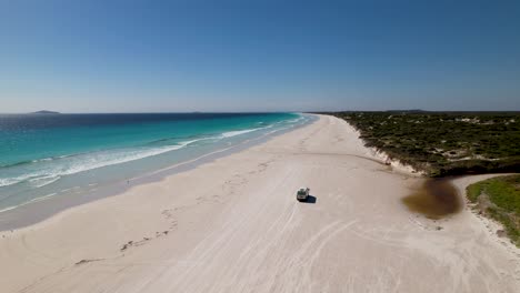 4K-drone-video-of-a-camper-van-driving-on-Le-Grand-Beach-in-the-Cape-Le-Grand-National-Park,-Western-Australia