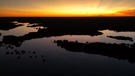 Atemberaubende-Drohnenaufnahmen-Des-Amazonas-Dschungels-Und-Des-Flusses-Bei-Sonnenaufgang,-Zeigen-Einen-Atemberaubenden-Goldenen-Farbton-über-Dem-üppigen-Regenwald-Und-Den-Gewundenen-Wasserwegen