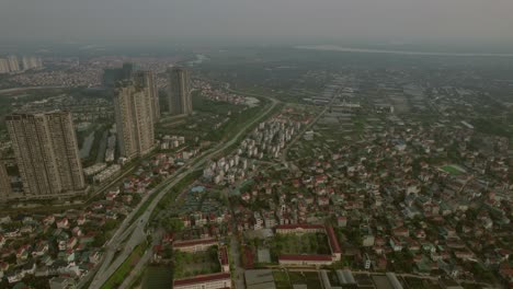 High-aerial-metropolitan-city-blending-into-rice-fields,-Hanoi,-Vietnam