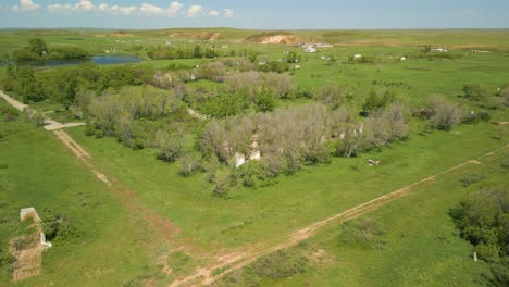 Blick-Auf-Eine-Grüne-Wiese,-Die-Ruinen-Eines-Verlassenen-Gebäudes-Und-Einen-Teich-In-Kasachstan,-Zentralasien-–-Luftaufnahme-Einer-Drohne