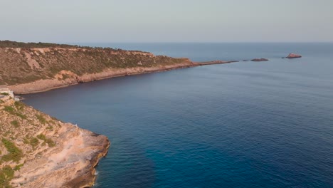 Dreamy-aerial-view-of-Punta-de-El-Toro-narrow-rock-formation-in-sea,-Spain