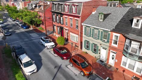 Aerial-approaching-shot-of-street-in-american-neighborhood-with-row-of-houses