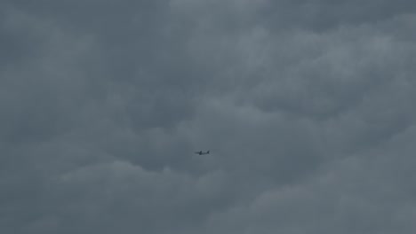 Airplane-flying-across-dramatic-overcast-sky