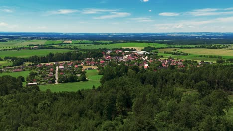 Flying-towards-a-czech-village-Choustník-over-a-forest-in-summer,-Europe