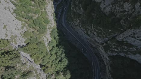 aerial-of-steady-stream-of-tourists-driving-Bicaz-Chei-mountain-river-valley,-Bicaz-Gorge,-Romania