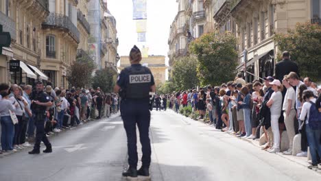 Toma-En-Cámara-Lenta-De-Un-Policía-Parado-En-La-Ruta-Del-Relevo-De-La-Antorcha-Olímpica.