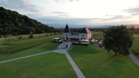 Drone-view-of-Chateau-Buera-Winery-and-Vineyards,-nestled-in-the-lush-green-mountains-near-Lopota-Lake-in-Georgia's-Kakheti-region