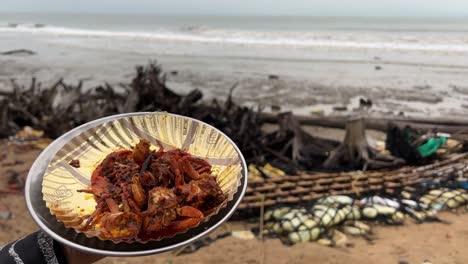 Spicy-red-crab-with-untidy-beach-and-waves-in-the-background