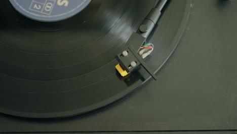 Close-up-of-a-vinyl-record-playing-on-a-turntable,-highlighting-the-retro-audio-equipment-in-action