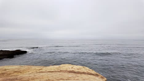 Sunset-Cliffs-sea-cave-in-San-Diego-California-spinning-left-shot-of-the-beach-and-the-rocks-on-the-shore-of-the-cove