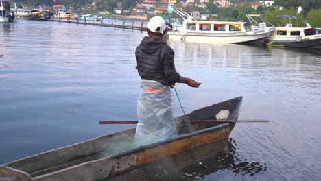 Hombre-En-El-Lago-De-Atitlán-Pescando-Con-Red-Y-Canoa-Rústica.