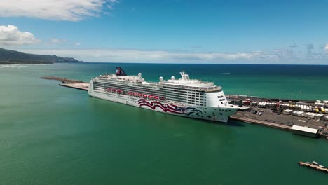 Drone-slowly-orbits-massive-tourism-cruise-ship-docked-at-port-in-Maui